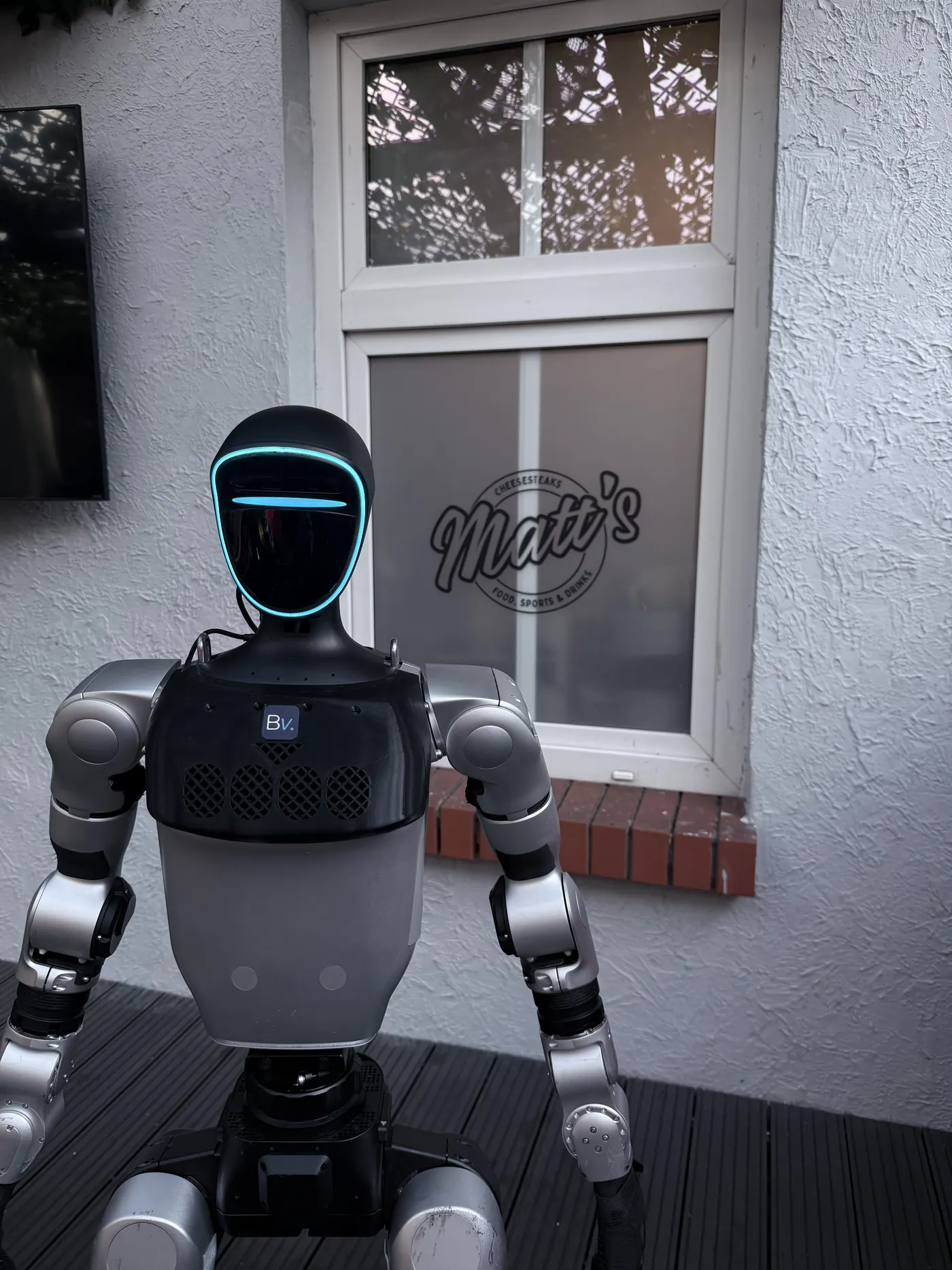 A Unitree G1 robot with the Botversity Voice chest unit mounted, seen from the front